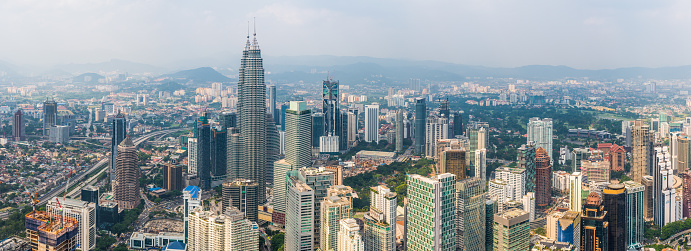Aerial view over the skyscrapers and landmarks of Kuala Lumpur, Malaysia's vibrant capital city, from the iconic spires of the twin Petronas Towers to the hotels and malls of Bukit Bintang.