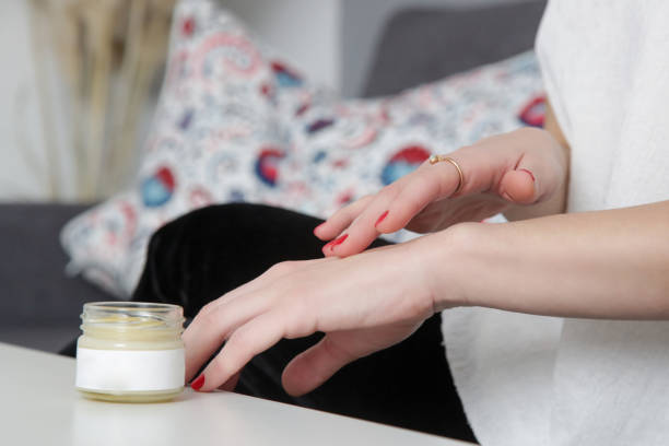 istock Closeup of female hands applying cream 1301369254