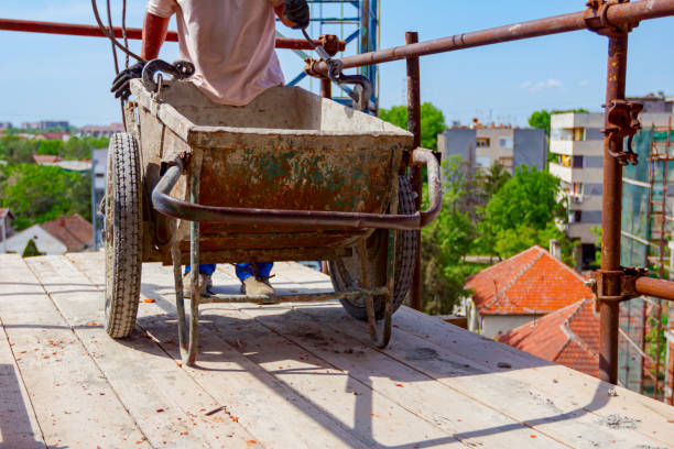 rigger sta fissando i ganci della gru alla carriola - scaffolding wheel construction site metal foto e immagini stock