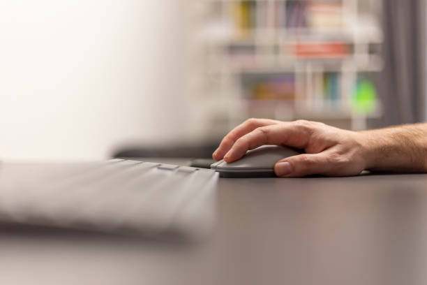 istock Close up view of a hand with a wireless mouse. Work from home, online study. 1301370914