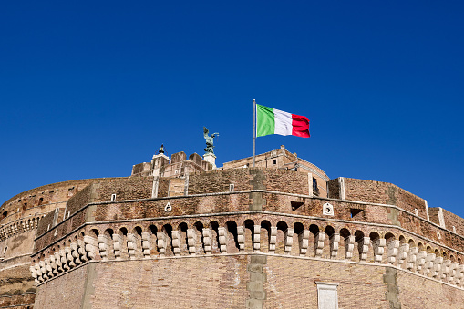 Rome, Italy, January 26 -- An Italian flag waving on Castel Sant'Angelo in downtown Rome. Built around 123 AD as a sepulcher for Emperor Hadrian and his family, the current Castel Sant'Angelo was used as a fortress, prison and refuge by the Popes due his proximity with the Vatican. It is currently owned by the Italian state and is used for visits and cultural events. Image in High Definition format.