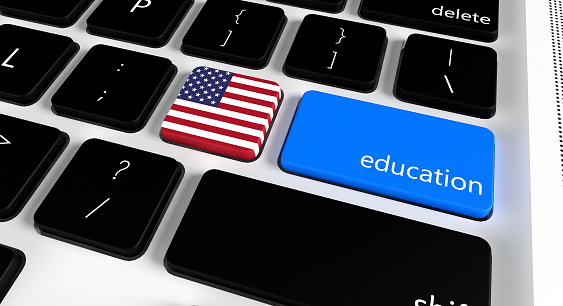 Computer keyboard with word Education and American Flag, selected focus on enter button.