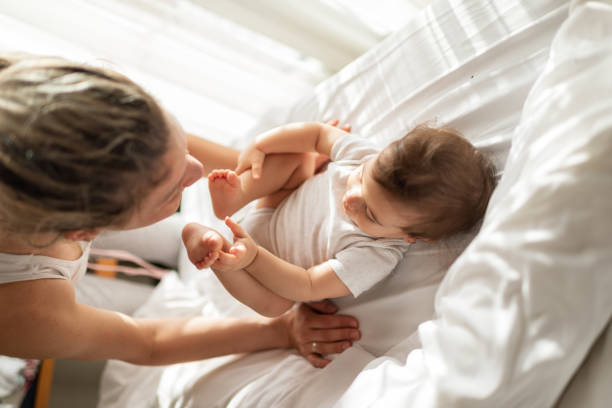 istock Mother and baby playing on bed 1301380858