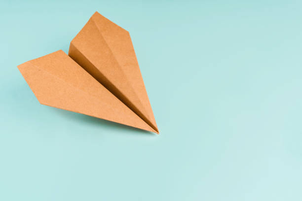 istock Paper airplane made of craft paper on a light blue background, space for text 1301381013