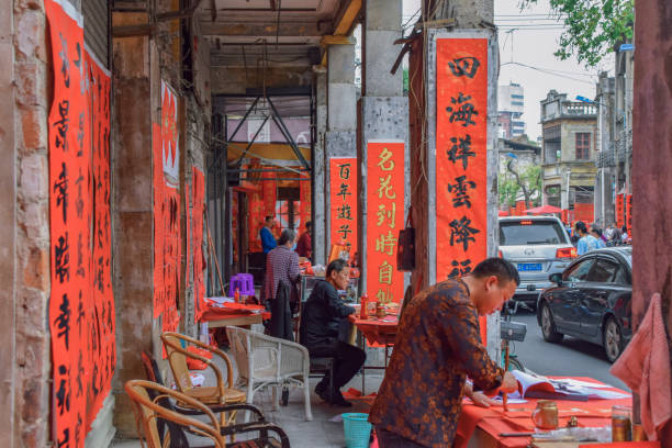 Foshan, Guangdong province, China. FEB 8, 2021. A calligrapher is writing Spring Festival Couplets for people. It is the most common and important custom when celebrating Chinese New Year.