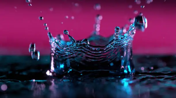 Abstract water crown shape illuminated by neon lights, freeze motion.