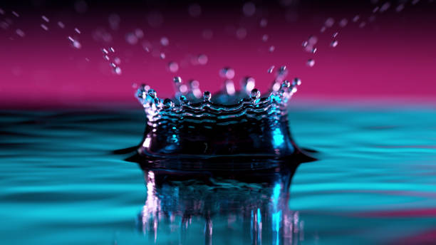 forma astratta della corona d'acqua illuminata da luci al neon - impact foto e immagini stock