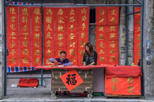 Foshan, Guangdong province, China. FEB 8, 2021. A calligrapher is writing Spring Festival Couplets for people. It is the most common and important custom when celebrating Chinese New Year.