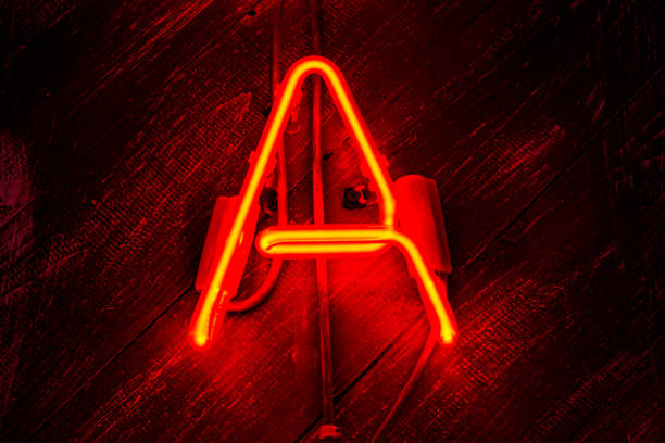 istock Glowing Neon red letter A on wooden background. 1301382995