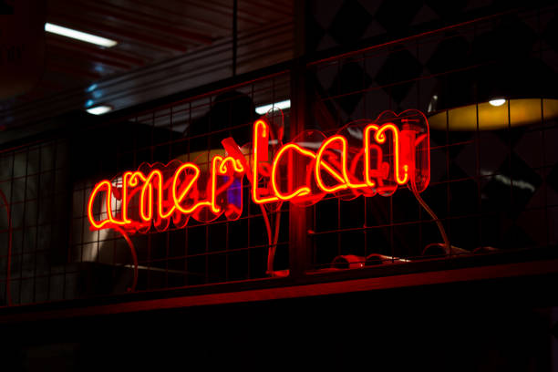 istock Glowing Neon red sign AMERICAN and blurred lights on black background 1301383002