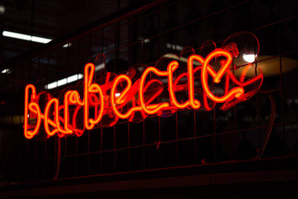 istock Glowing Neon red sign AMERICAN and blurred lights on black background. 1301383023