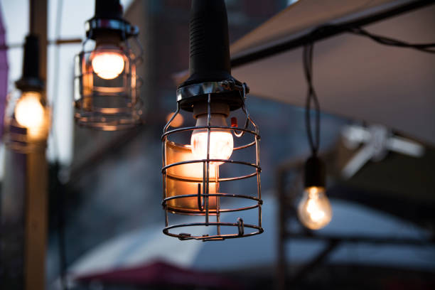 Vintage metal cap lamp Vintage metal cap lamp hanging from the ceiling and blurred lamos on back. antique blue wine goblets stock pictures, royalty-free photos & images