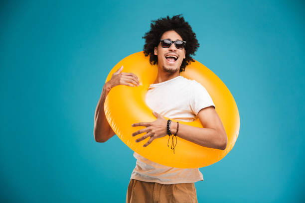 istock Handsome young african curly man holding rubber ring. 1301384520