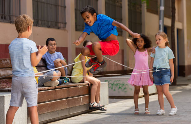 mexikanische junge spielen gummiband springen spiel mit freunden - rope way stock-fotos und bilder