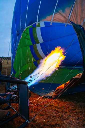 Hot air balloon pilot operating the burners. Low angle inside view
