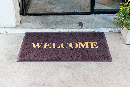 Welcome mat in shop front of door.