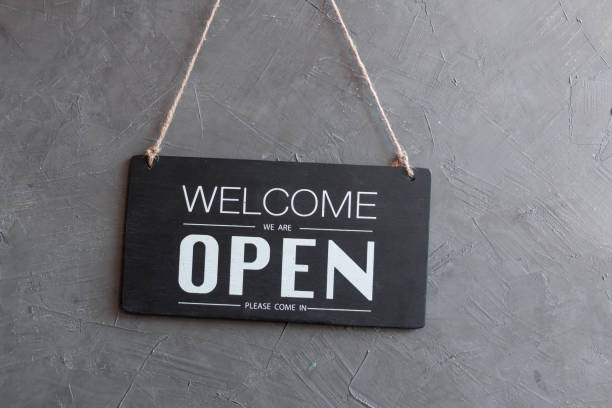 istock Come in we're open, vintage black retro sign in back wall 1301395245