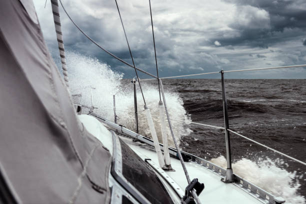 Sailing under storm clouds stock photo