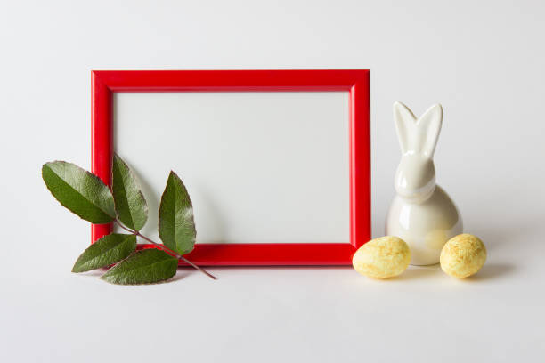 istock Red wooden frame with Easter bunny yellow eggs and branch 1301396058