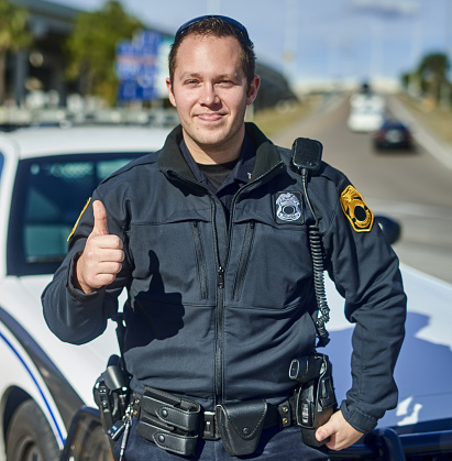 Cropped portrait of a handsome young policeman giving thumbs up while out on patrol
