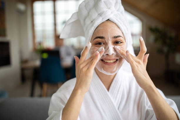 Portrait of beautiful woman enjoying her beauty treatment at home Portrait of beautiful woman in bathrobe enjoying her beauty treatment at home woman washing face stock pictures, royalty-free photos & images