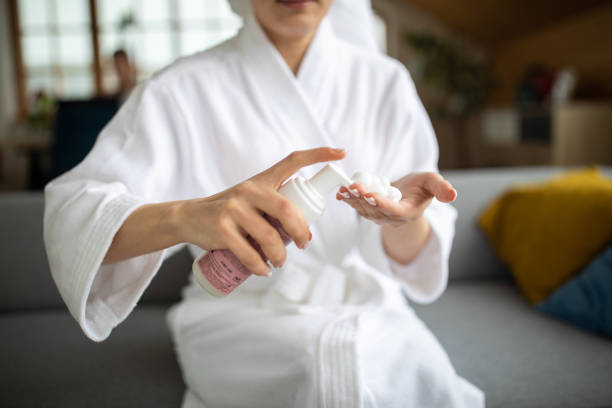 istock Young woman using beauty product while relaxing at home 1301397216