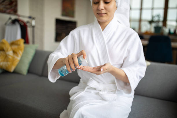 istock Young woman using beauty product while relaxing at home 1301397375