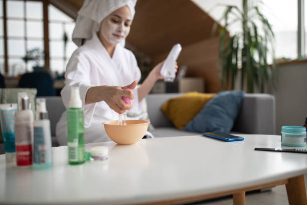 istock Young woman using beauty product while relaxing at home 1301397419