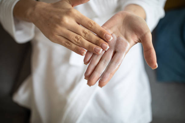 istock Woman applying hand cream at home 1301397759