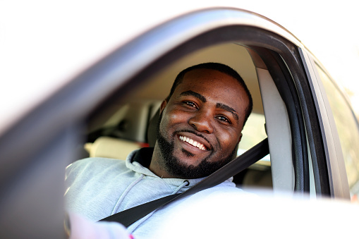 Young man driving a car. About 30 years old, African male.