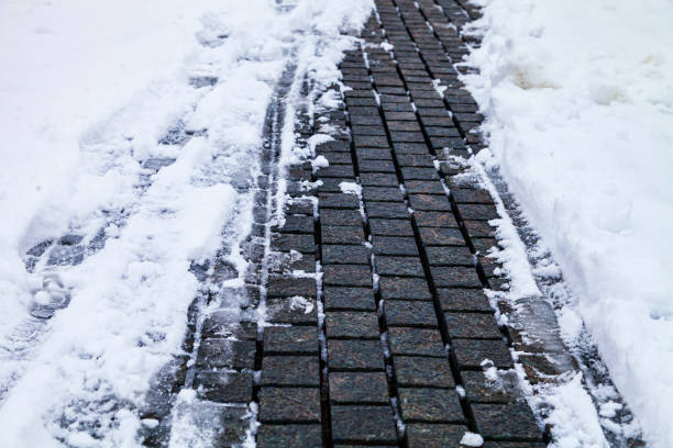 Stone path in the park in the snow close-up. Winter in the city.