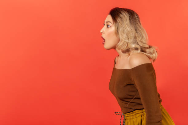 istock Woman standing surprised with open mouth, side view 1301401278