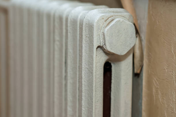 istock Element of white old cast iron battery for heating room in cold season 1301401515
