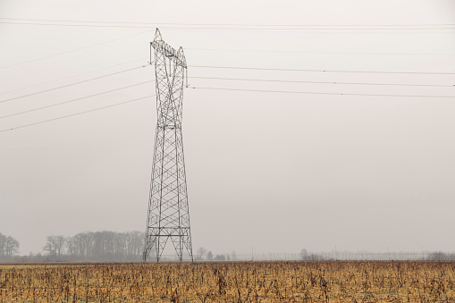 Electricity pylons in the countryside. Electricity pylon in the middle of agricultural field.