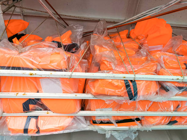 orange life jacket or vest on shelf prepare for safety on transportation boat. recue clothes for tourism in cruise. - daily cruiser imagens e fotografias de stock