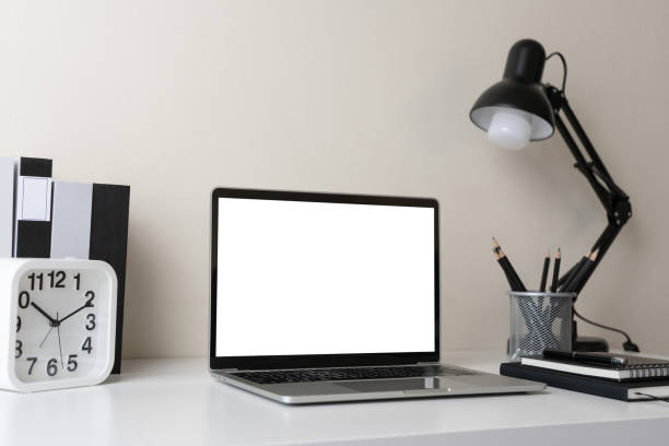 istock Modern contemporary workspace with blank screen laptop computer with office supplies and stationery on office desk on white background for copy space. Home office workplace concept. 1301403754