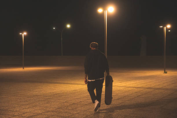 istock Young Men With Skateboard at Night 1301403885