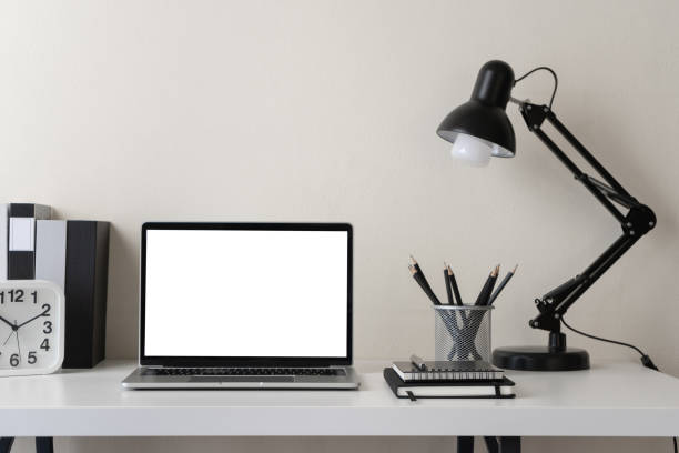 istock Modern contemporary workspace with blank screen laptop computer with office supplies and stationery on office desk on white background for copy space. Home office workplace concept. 1301404179