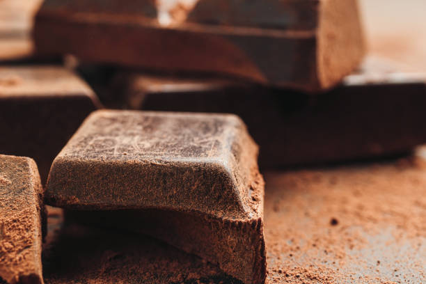 istock Chocolate bar and chopped chocolate cubes on dark background, close-up view 1301404304