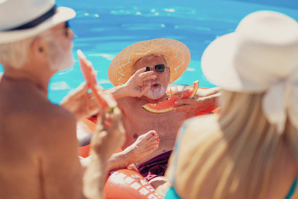 istock Elderly people sunbathing and eating watermelon by the pool 1301404476