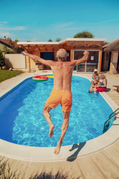 Photo of Elderly man jumping into swimming pool