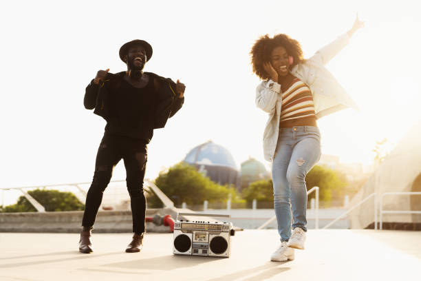 young afro friends dancing outdoor while listening to music with wireless headphones and vintage boombox - african dance imagens e fotografias de stock