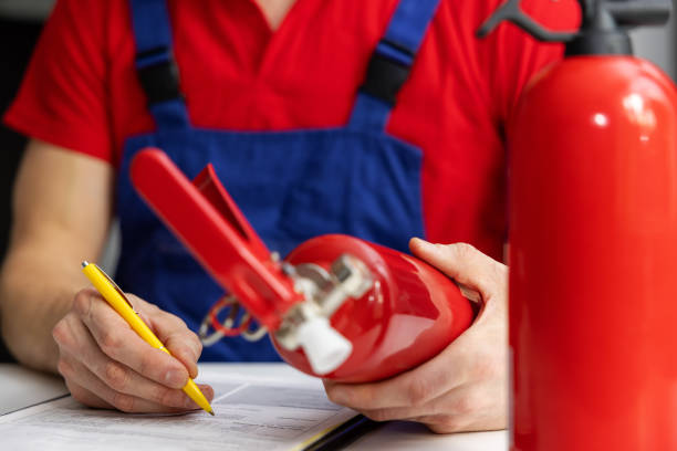 brandschutzausrüstung wartung - service-ingenieur überprüfung feuerlöscher zustand und schreiben von dokumenten - löschpapier stock-fotos und bilder