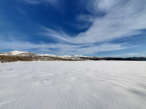 Natural sunset sunrise over field or meadow. The color of the sky over the winter snowy ground. Landscape under a picturesque sky at sunset. Dawn of the sun. Skyline, Horizon.