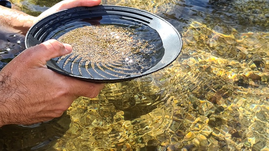 Sunny day recreational activity gold panning in a mountain creek. Snowy Mountains, Kosciuszko National Park, NSW