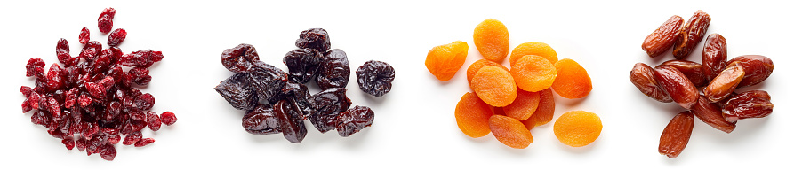 Heap of dried apricots, cranberries, dates and prunes isolated on white background, top view