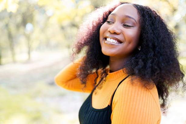 istock Cute black woman smiling in a park 1301411069