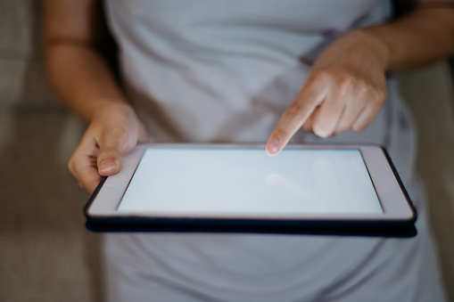 Close up of hand of an Asian woman using a digital tablet