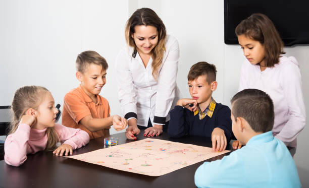istock Children making move on pre-marked surface of board game 1301411373