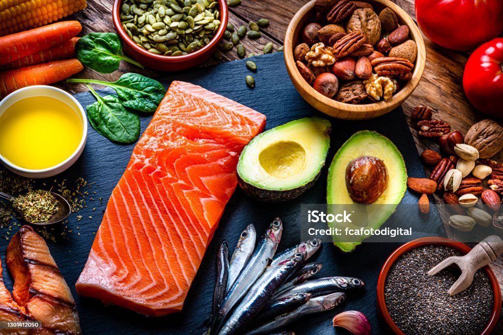 Food with high content of Omega-3 fats Healthy eating: high angle view of a group of food with high levels of Omega-3 fat. The composition includes salmon, sardines, avocado, extra virgin olive oil, and various nuts and seeds like pumpkin seeds, chis seeds, pecan, almonds, pistachio, walnuts and hazelnuts. High resolution 42Mp studio digital capture taken with Sony A7rII and Sony FE 90mm f2.8 macro G OSS lens Healthy Eating Stock Photo